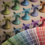Wall decorated with repeating multicolored 3D cross shapes and a curved rainbow fabric swatch in the foreground.
